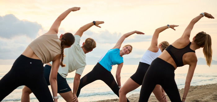 Animateurin leitet Fitnessgruppe am Strand